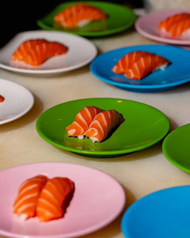 Nigiri al salmone sui piattini colorati del kaiten