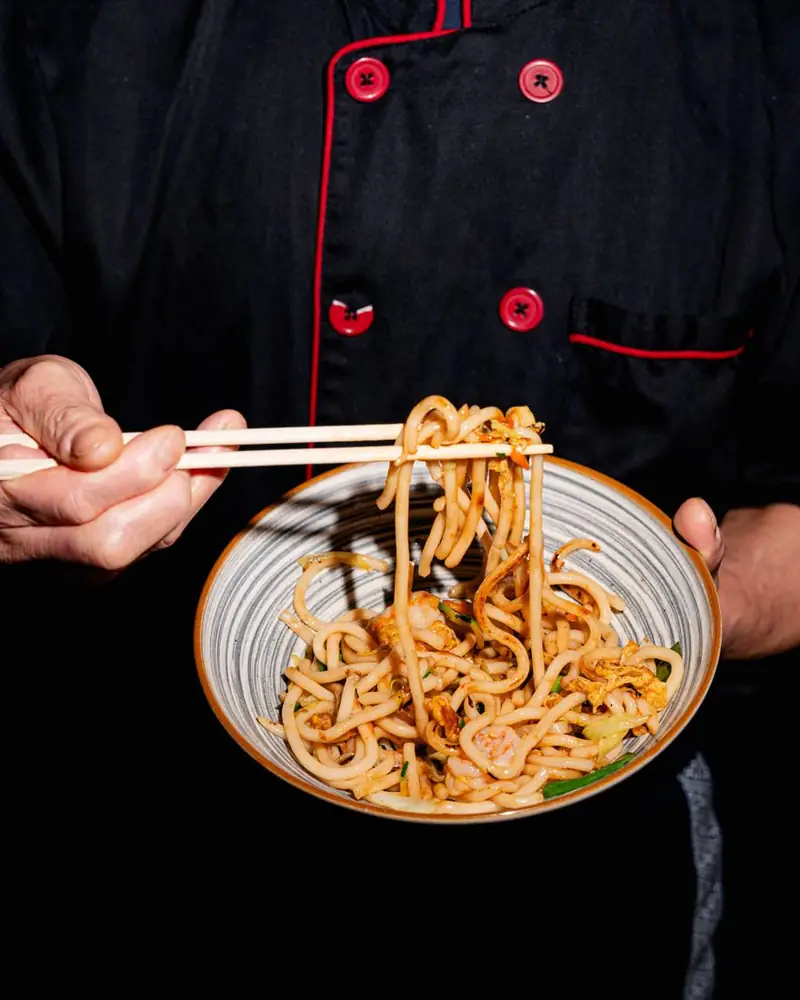 Udon saltati con gamberi sollevati con le bacchette